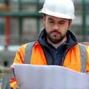 Thibault Girard en veste de chantier, consultant des plans.